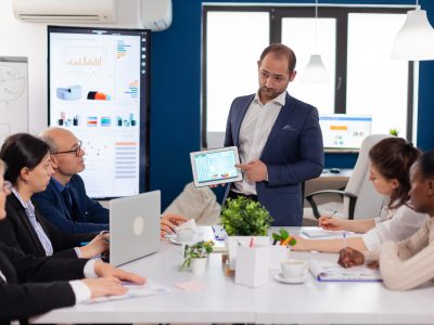 Company leadership explaining briefing project Company leadership explaining briefing project in conference room to team. Project leader discussing with teamworkers in broadroom, analysing charts, graphs, financial evolution of company.